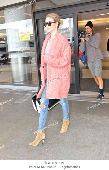 Rosie Huntington-Whiteley arrives at Los Angeles International Airport (LAX) wearing a large pink coat Featuring: Rosie Huntington-Whiteley Where: Los Angeles