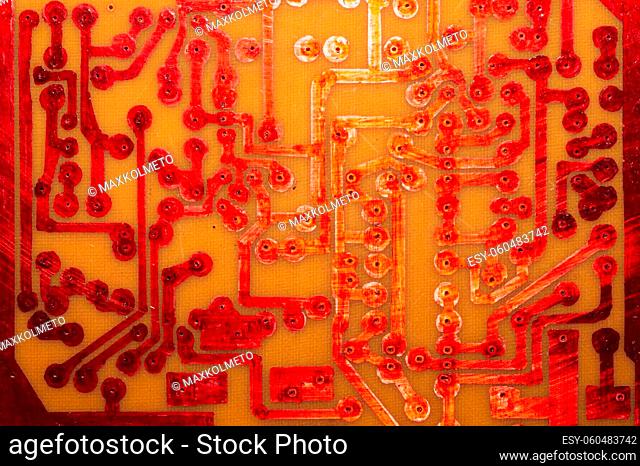 Handmade circuit board with red soldered tracks. industrial background. textolite with soldering