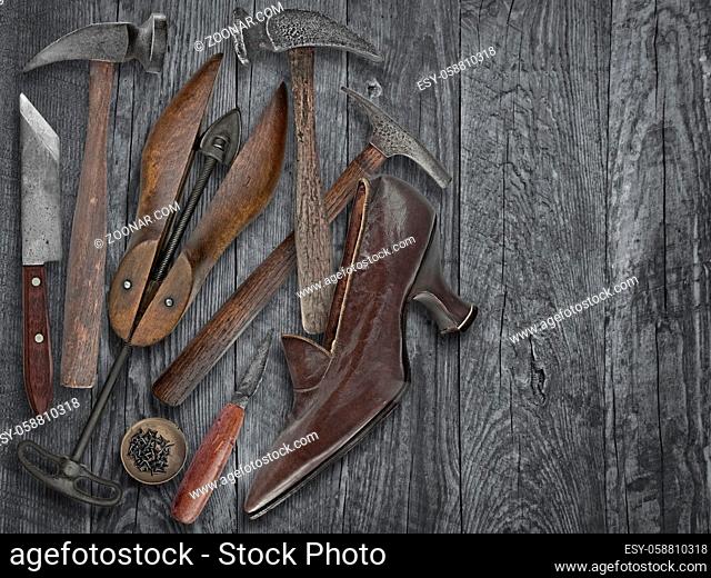 vintage ladies shoe and shoemakers tools over wooden table, space for your text