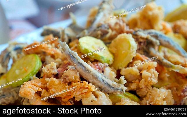 Tasty Italian dish fried seafood: shrimp, squid, octopus and a slices of zucchini. Italian fast food. High quality photo