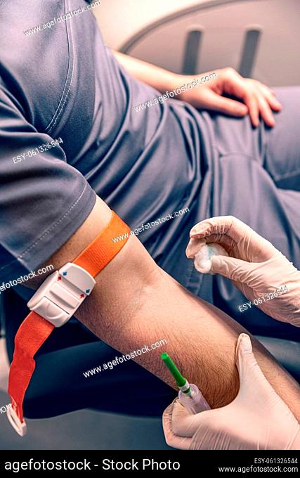 Nurse disinfecting male arm before blood test