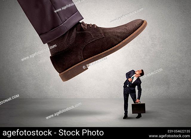 Employee is afraid of the big boss foot, which is stepping down him