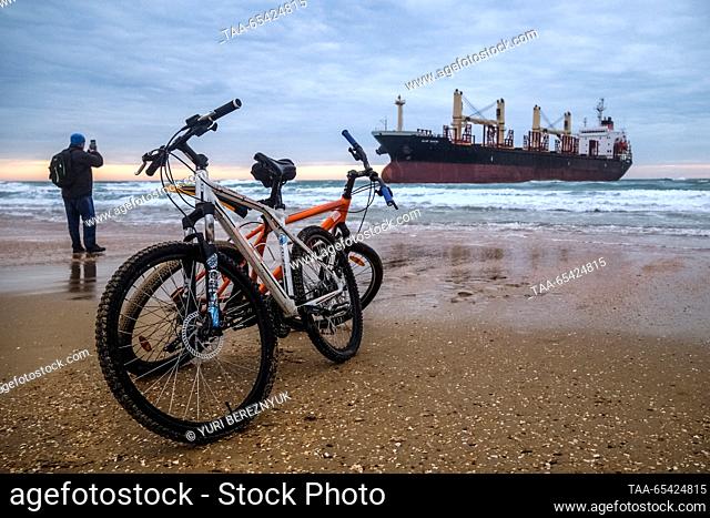 RUSSIA, KRASNODAR REGION - DECEMBER 2, 2023: A man takes a photograph of the Blue Shark dry cargo ship after it ran aground at the Black Sea resort of Anapa