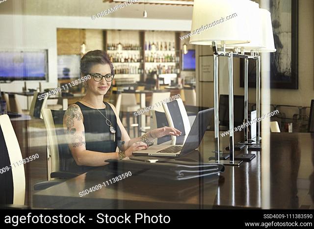 Caucasian woman using laptop at restaurant table