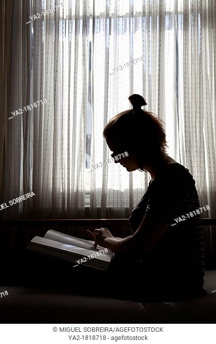 Girl on Settee reading Book