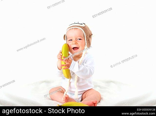 little baby in knitted montey hat on brown blanket