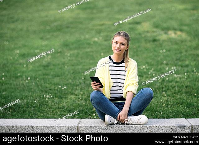 Woman with her phone sitting in public park