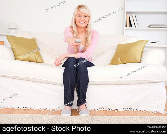 Beautiful blonde female posing while sitting on a sofa
