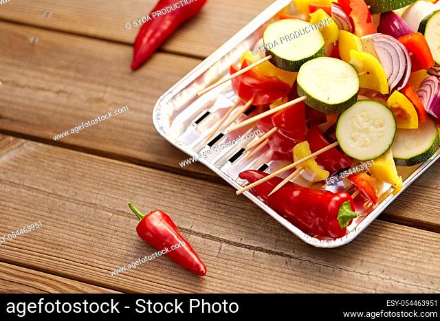 close up of vegetables on skewers on foil grill