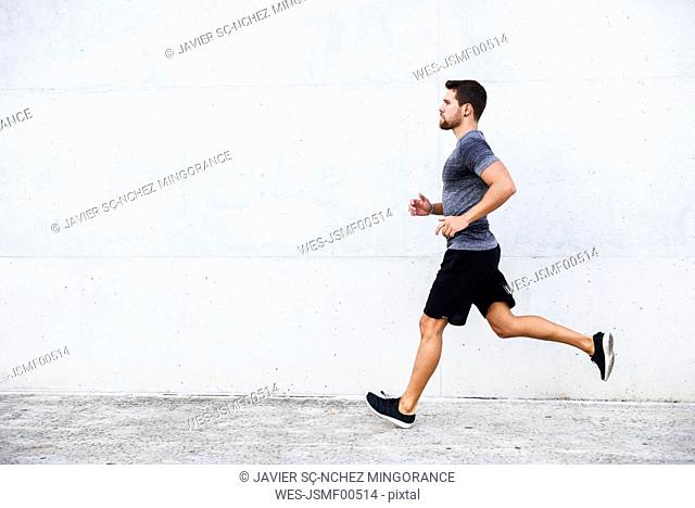 Athlete running in front of white wall