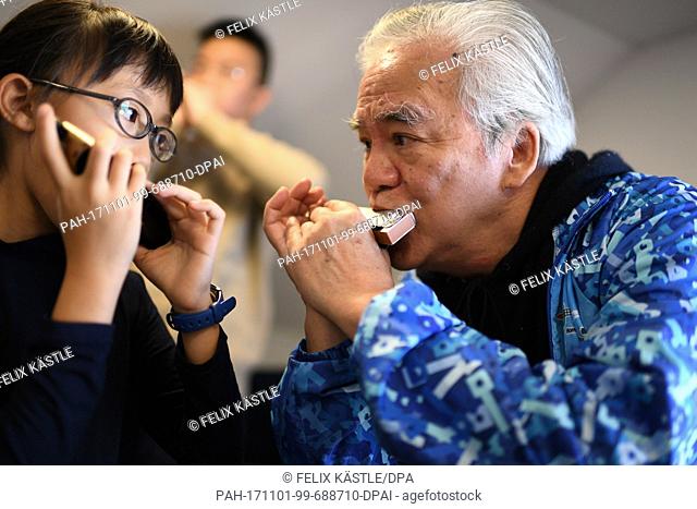 Lenng Tsz Kiu Amanda of the Kings College Old Boys Association from Hong Kong warms up with his harmonica in Trossingen, Germany, 1 November 2017