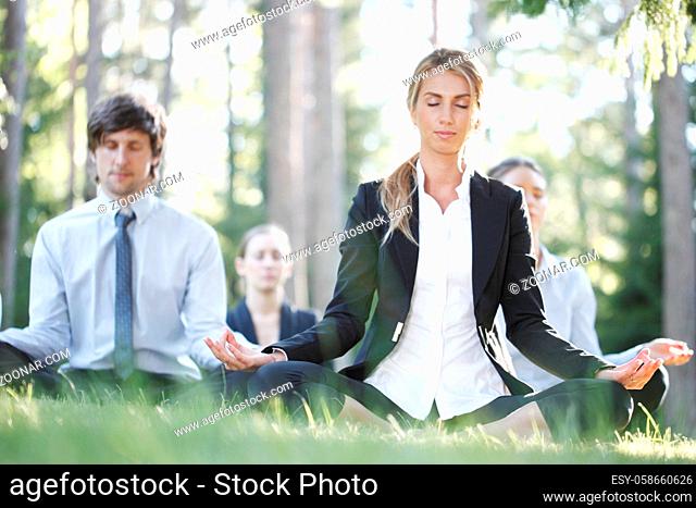 Business people team practicing yoga in park taking a break