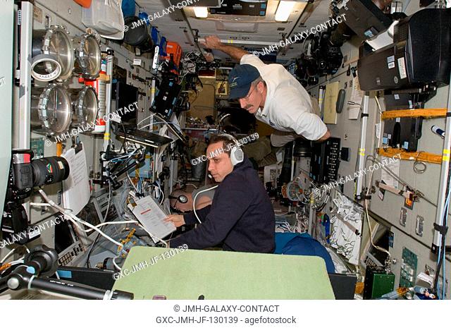 Russian cosmonaut Anton Shkaplerov (bottom), Expedition 30 flight engineer, monitors data at the manual TORU docking system controls in the Zvezda Service...