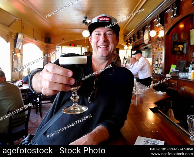 PRODUCTION - 19 September 2023, USA, San Francisco: Customer Sean Brown stands at the counter of the Buena Vista Cafe with his freshly mixed Irish Coffee...
