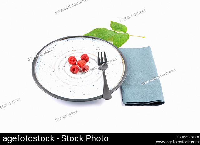 Himbeeren auf Teller und weiss - Red raspberries on plate and white