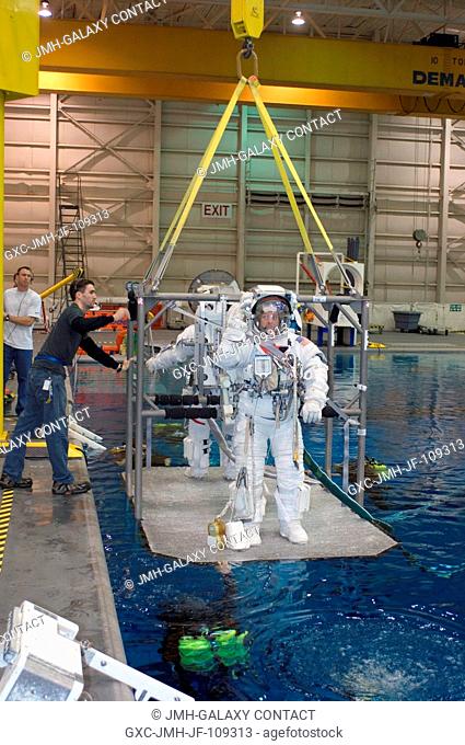 Astronauts Ronald J. Garan and Michael E. Fossum (partially obscured), both STS-124 mission specialists, are about to be submerged in the waters of the Neutral...