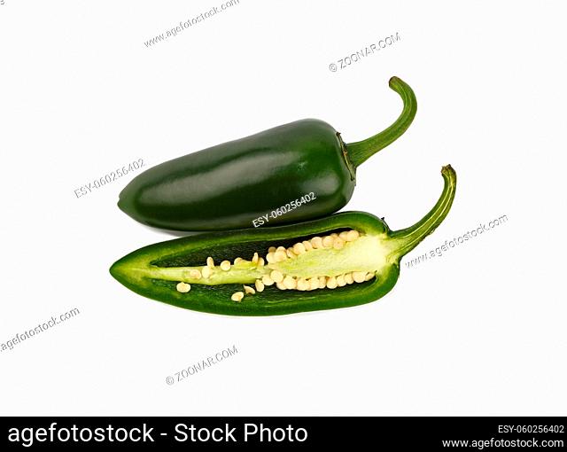 Close up one whole and half cut slice of fresh green jalapeno hot chili pepper isolated on white background, high angle side view