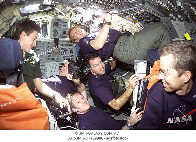 Five astronauts and a Russian cosmonaut share space on the flight deck of the Space Shuttle Discovery following that spacecraft's separation from the...