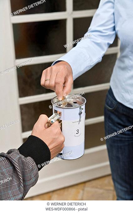 Teenage boy donating money at door