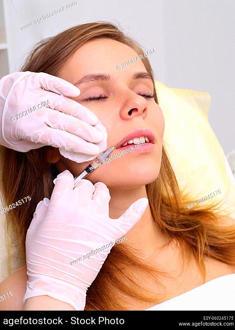 Beautiful girl on rejuvenation procedure in beauty clinic filler injection. Injection in her lips