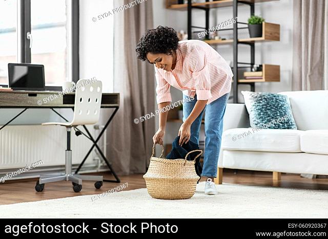 happy woman with blanket and wicker basket at home