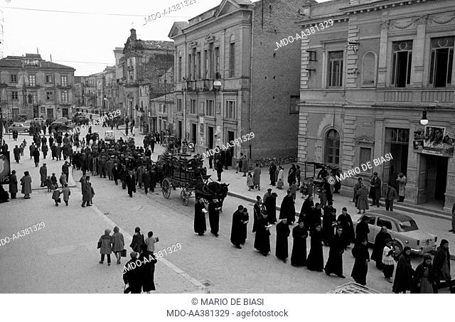 A funeral procession . Some Sicilian priests leading the funeral procession. Sicily, March 1958