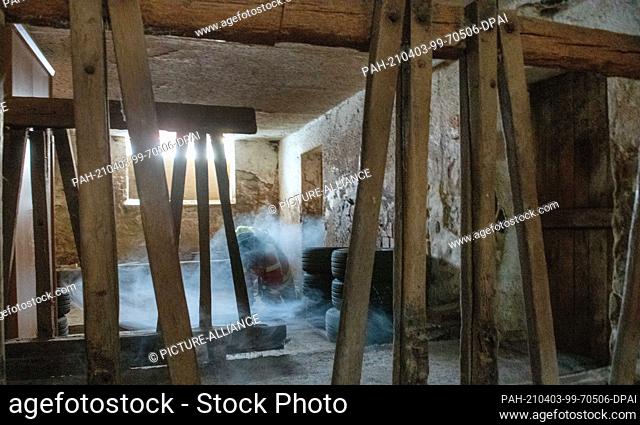 26 March 2021, Bavaria, Wemding: A firefighter crawls through smoke in a cow barn. Since no respiratory protection training can take place at the moment due to...