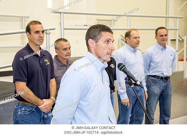 NASA astronaut Michael Hopkins (foreground), Expedition 3738 flight engineer, speaks to a crowd during a cake-cutting ceremony in the Jake Garn Simulation and...