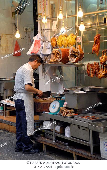 Hong Kong, China, Asia. Hong Kong Kowloon. Roadside butcher with large knife at work