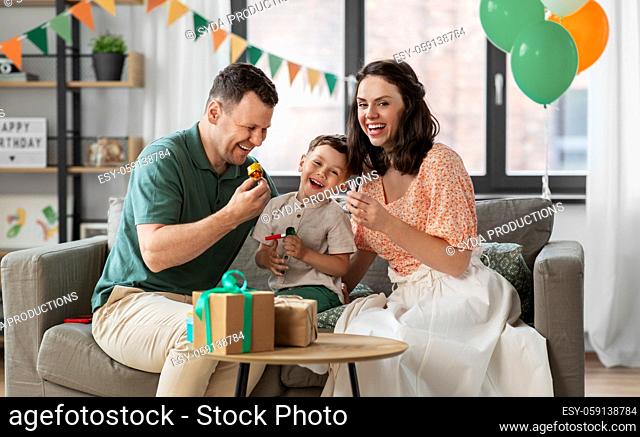 happy family with gifts and party blowers at home