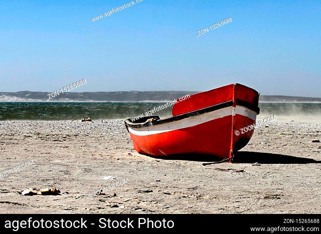 colorful fishing boat on a beach of a south african village. Red fishing boat