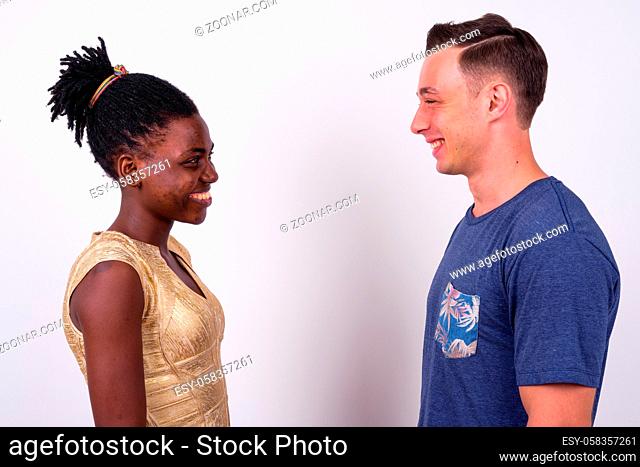 Studio shot of young handsome man and young African woman together and in love against white background
