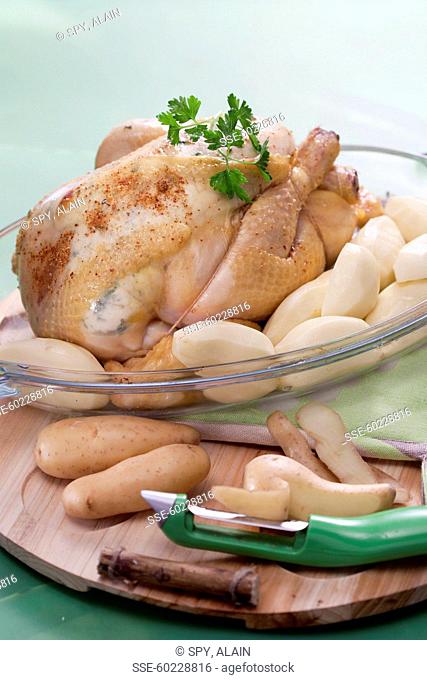 Placing the peeled potatoes around the chicken in a baking dish