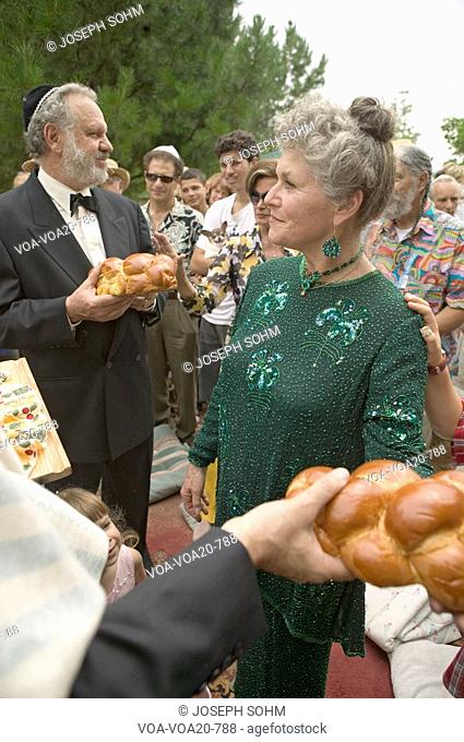 Bride, groom and guests break bread at a traditional Jewish wedding in Ojai, CA