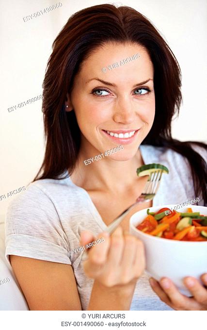 Portrait of charming Caucasian woman eating healthy vegetable salad