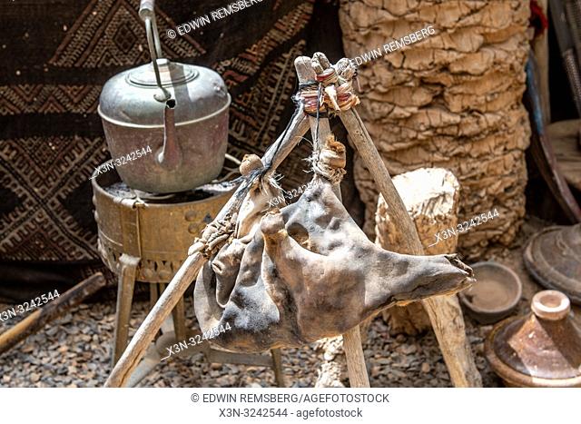 Waterskin hung on sticks next to teapot on top of grill, Tighmert Oasis, Morocco