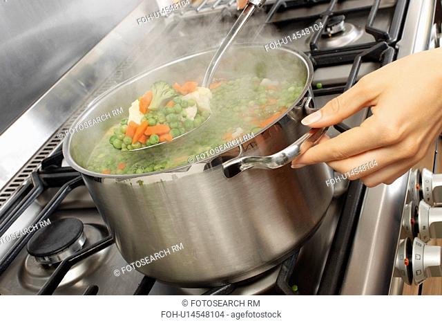 Woman In Kitchen Cooking Mixed Vegetables
