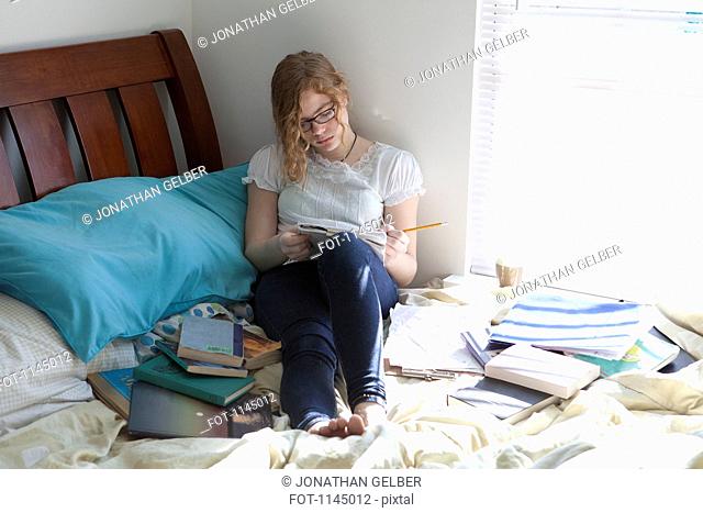 Busy girl with study books on bed