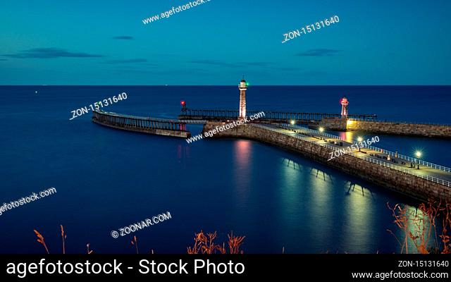 Whitby, North Yorkshire, England, UK - September 12, 2018: Evening light over the Whitby harbour and pier, seen from the East Terrace