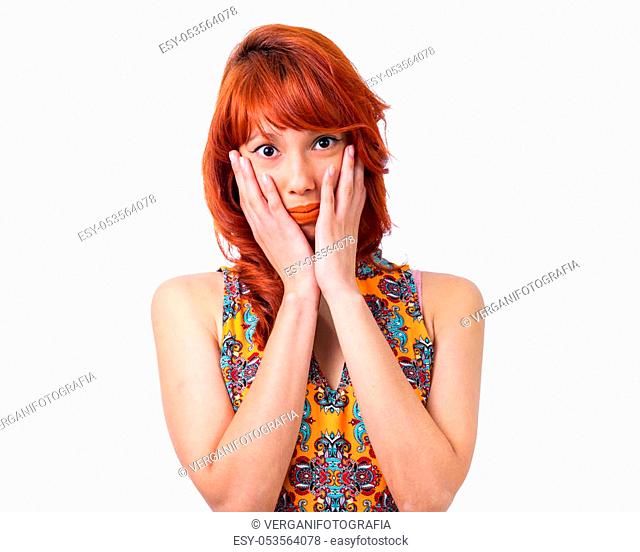 Woman covers her face with her hands. Surprise. Shy. Redhead girl wearing yellow and colorful dress. Floral pattern. Fashion and style