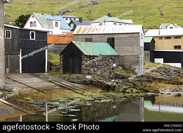 Old fishing huts with rusty metal roofs. Sörvagur, Faroe Islands