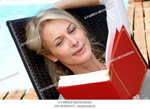 Portrait of woman reading book outside