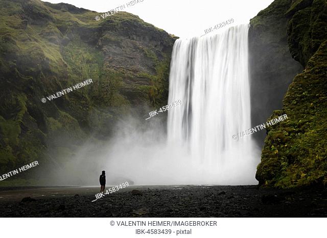 Person in front of waterfall Skogafoss, long-term exposure, Skogar, Iceland