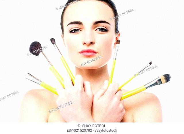 Beautiful girl holding makeup brushes set