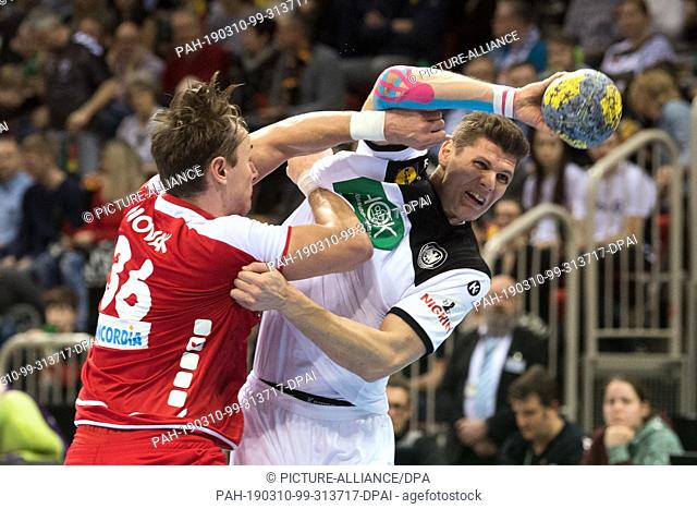 09 March 2019, North Rhine-Westphalia, Düsseldorf: Handball: International match, Germany - Switzerland in the ISS Dome. Germany's Sebastian Heymann (r) and the...