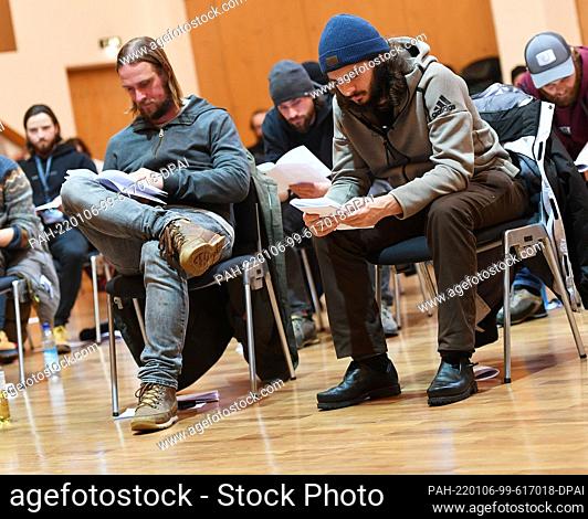 06 January 2022, Bavaria, Oberammergau: The two Jesus actors Frederik Mayet (l) and Rochus Rückel follow the text during the reading rehearsal for the 42nd...