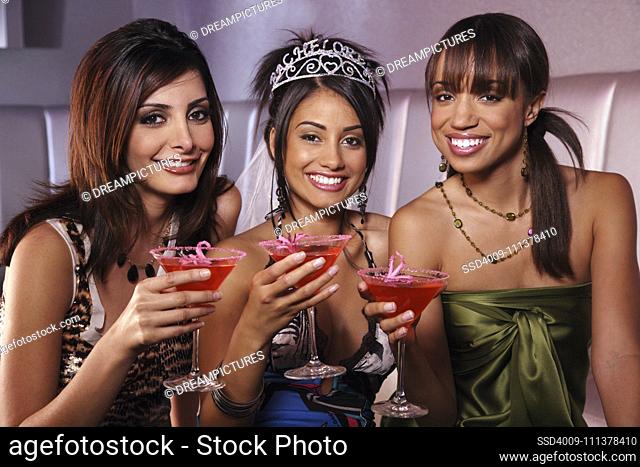 Multi-ethnic women drinking at bachelorette party