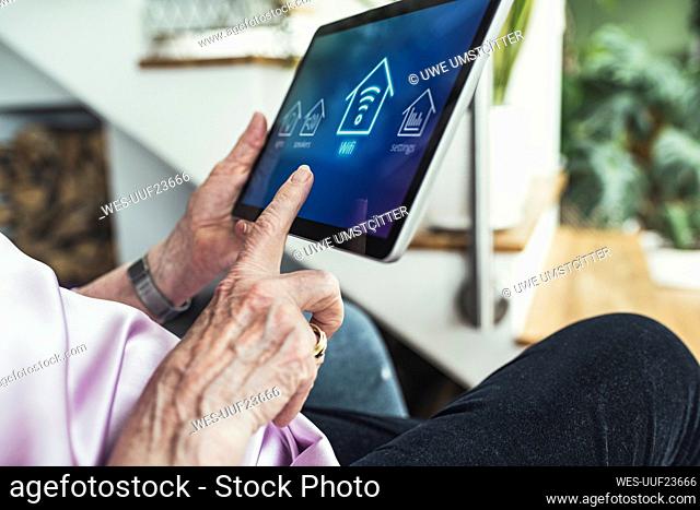 Woman connecting digital tablet with wifi at home