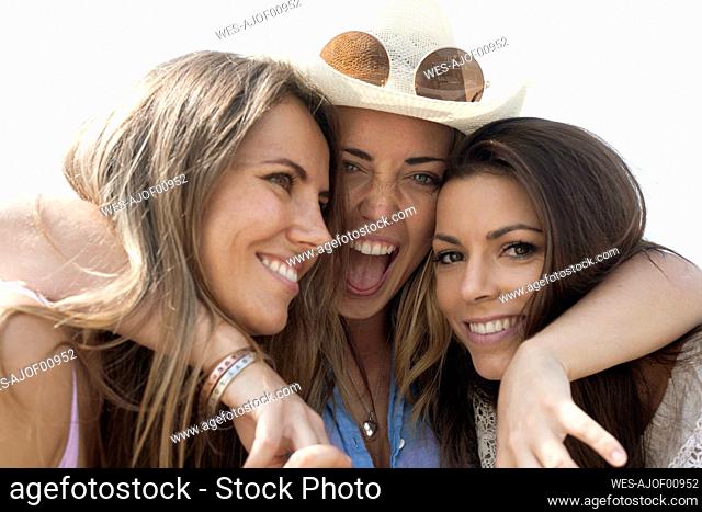 Excited woman embracing female friends during vacation