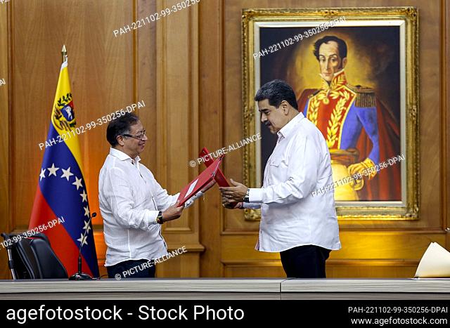 02 November 2022, Venezuela, Caracas: Colombian President Gustavo Petro (l) and his Venezuelan counterpart Nicolas Maduro exchange treaties after signing...